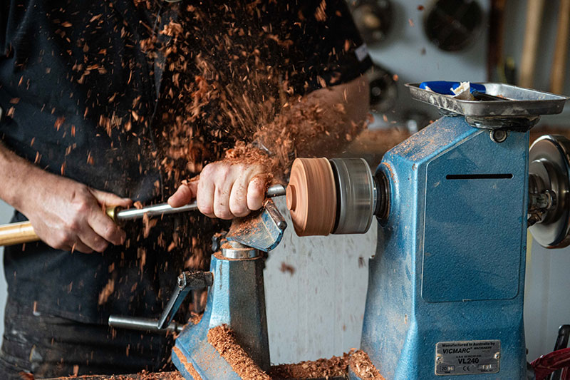 Army veteran Kerry Corney woodturning a wooden bowl into shape. 