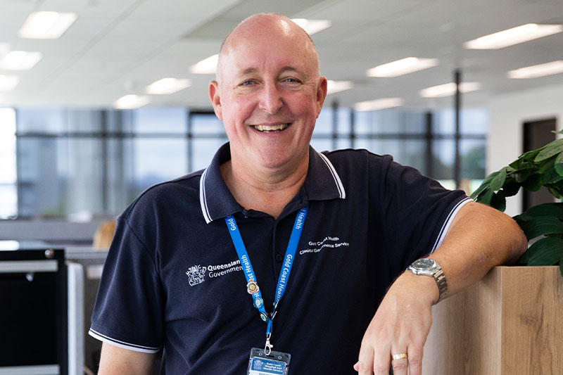 Ken Orr standing inside an office building smiling at the camera. 