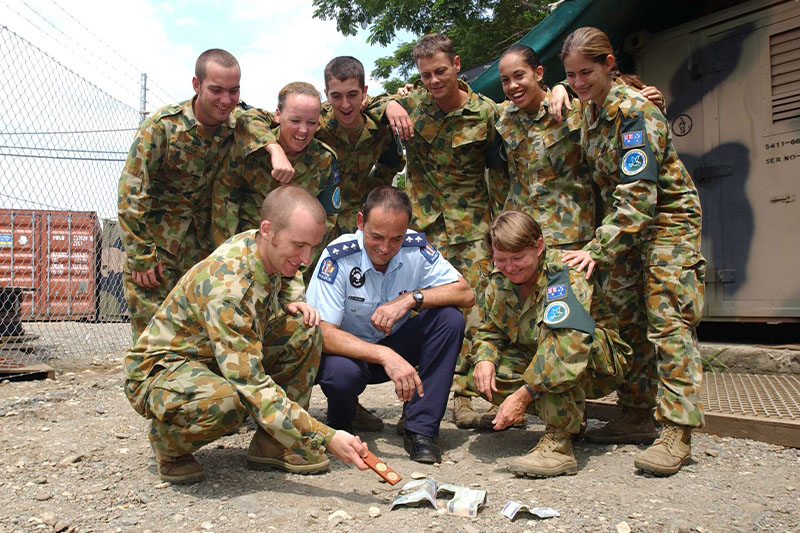 Image: Defence Australia |  hoto By Leading Seaman (LSPH) Ollie Garside Service people are practicing their two-up skills for Anzac Day in Honiara, Solomon Islands