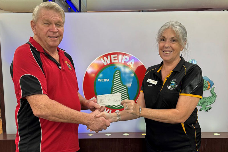 Lloyd accepting a donation from Weipa Bowls Club operations Manager Karen Phillips (image credit: Cape York Weekly)
